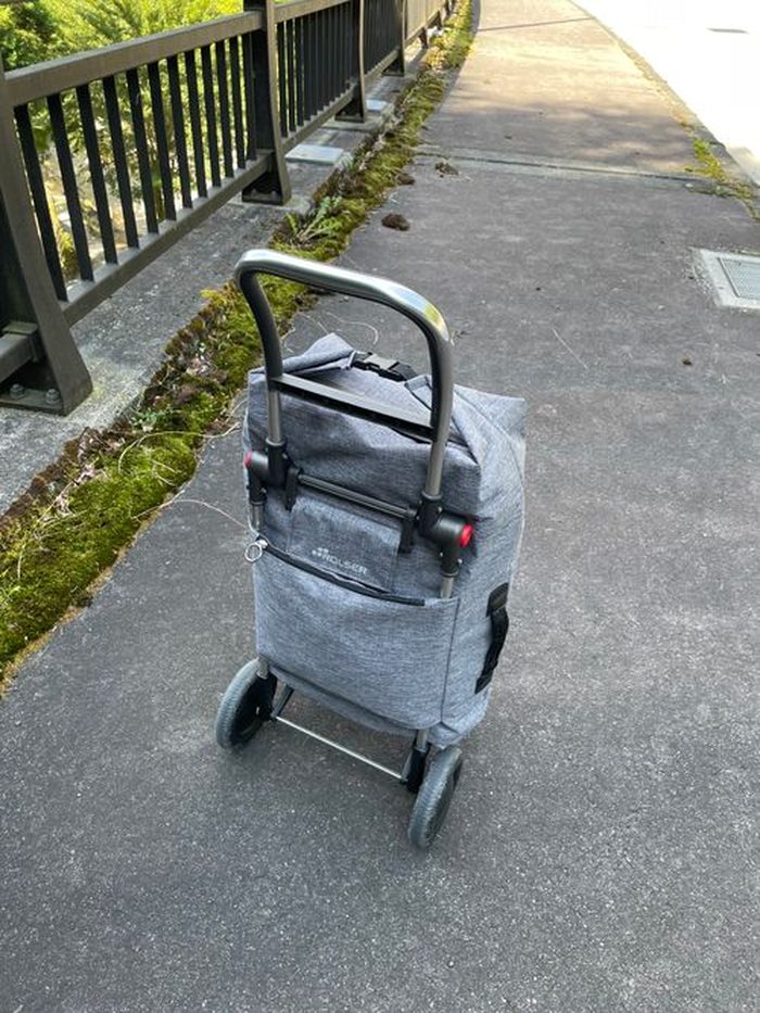 道路脇に立てたロルサーのキャリーカート。ロールトップ式のグレーのバッグ