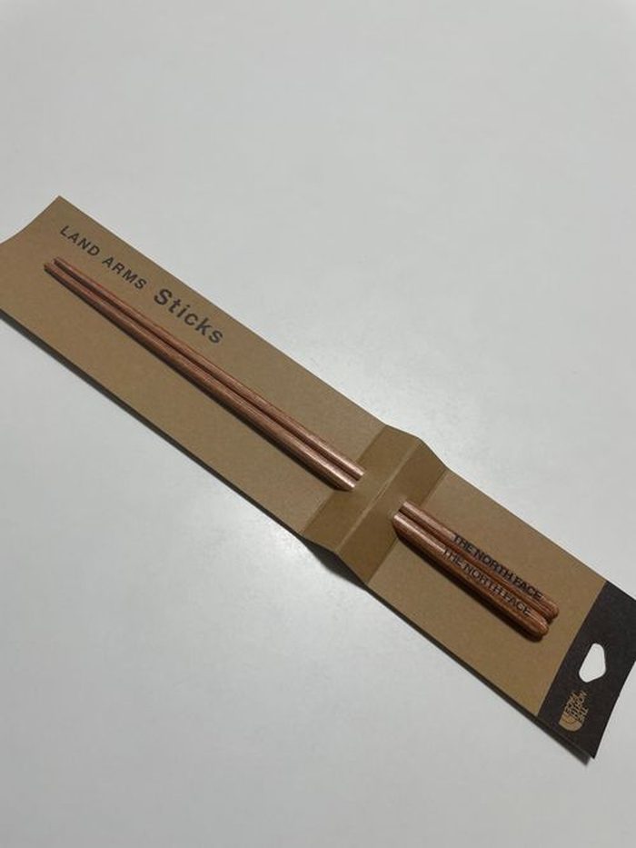 パッケージと並べたTHE NORTH FACEランドアームススティックス。木目の美しい箸