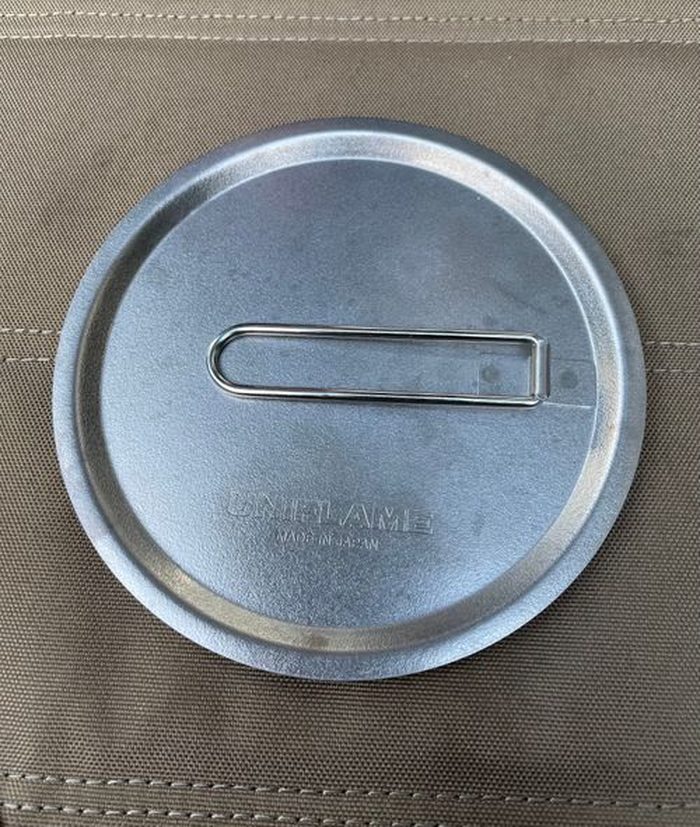 Helinoxテーブルの上に重ねて置いたUNIFLAMEのフタとフライパン。折りたたみハンドル付き