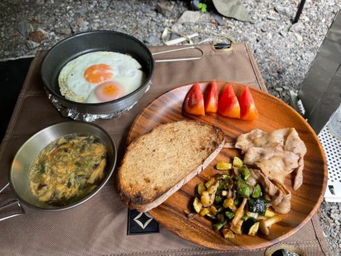 野菜炒めと目玉焼き、焚き火焼きパン、トマトのワンプレート朝食